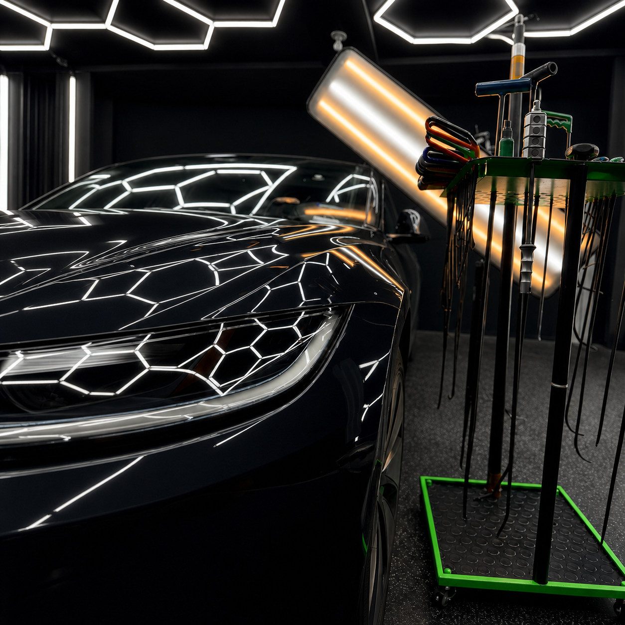 Professional PDR tools beside a vehicle under reflection lights at Dent Garage